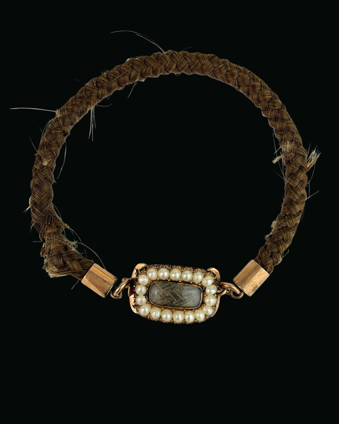 Georgian mourning bracelet of plaited brown hair with a gold and seed pearl clasp, whole view on black, IM-0001