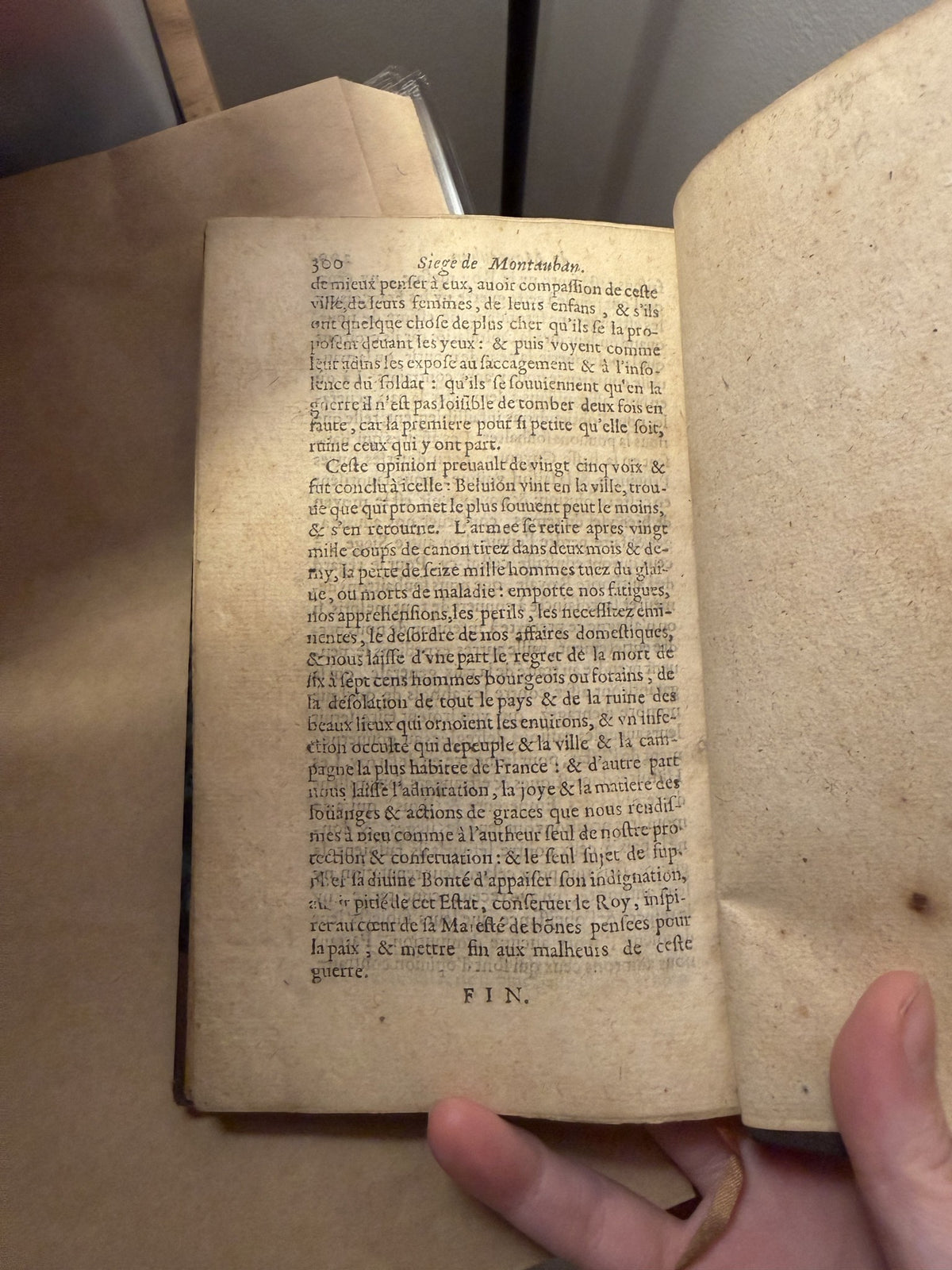 Final page of the Siege de Montauban ending in FIN, the book held open in one hand, IM-0049