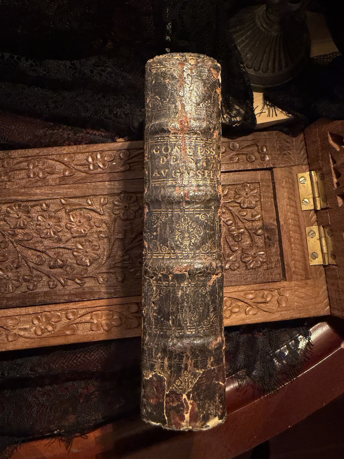 Spine of Les Confessions de S. Augustin, raised bands and faded gilt lettering on dark calf, IM-0050