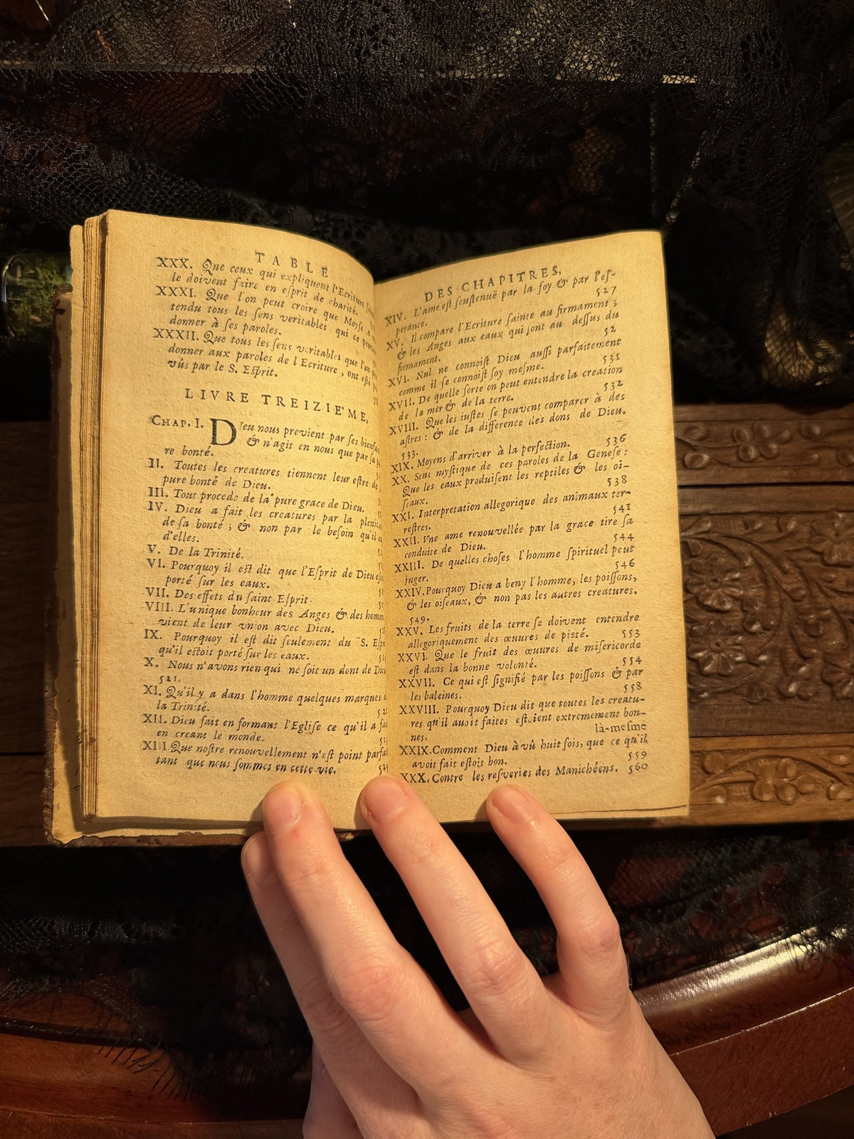 Table of chapters open across two pages, the book held flat in one hand, Les Confessions, IM-0050