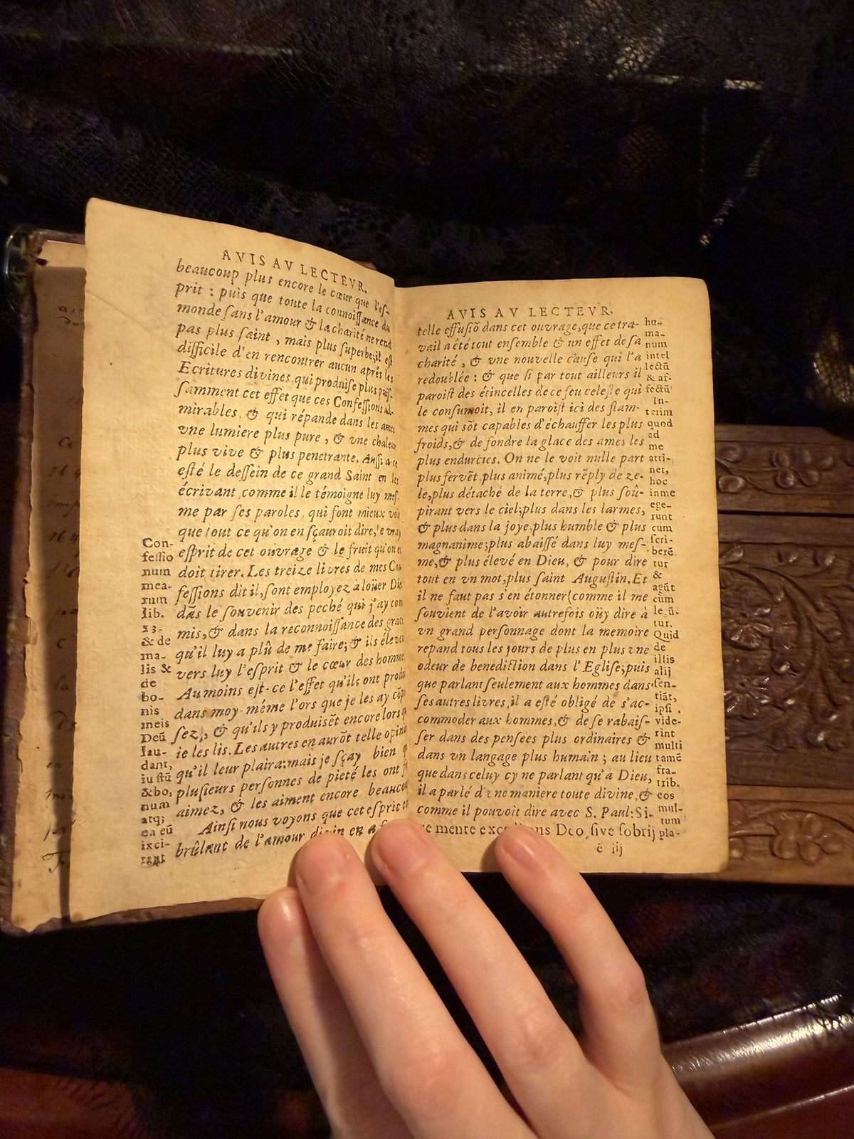 Two page spread of the Avis au Lecteur with printed side notes, the book held open, IM-0050