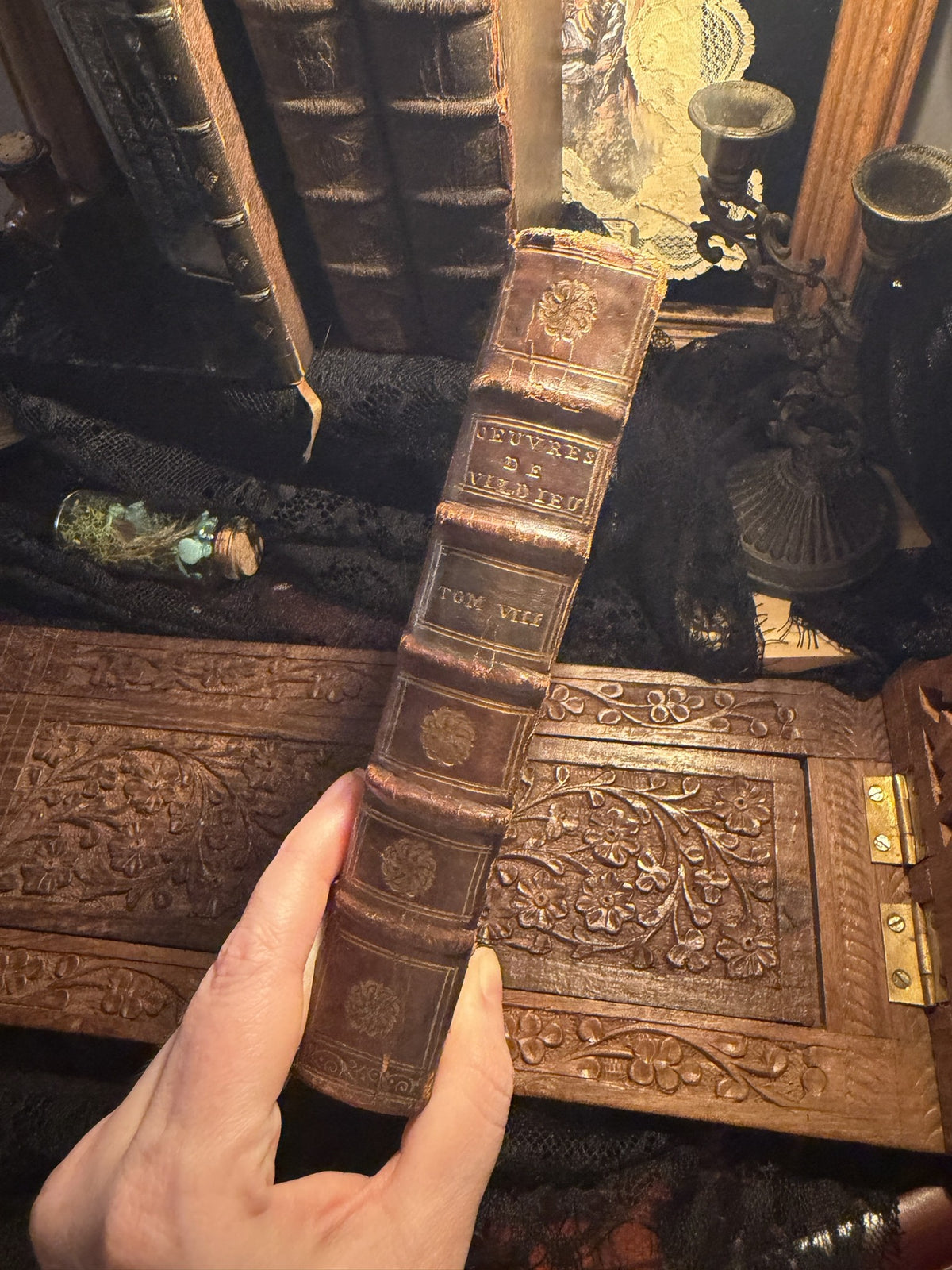 Gilt tooled calf spine of Les Exiles, Tome VIII, held above a carved wood panel, IM-0053